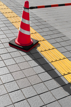 Traffic Cone Next to Tactile Paving on City Sidewalk