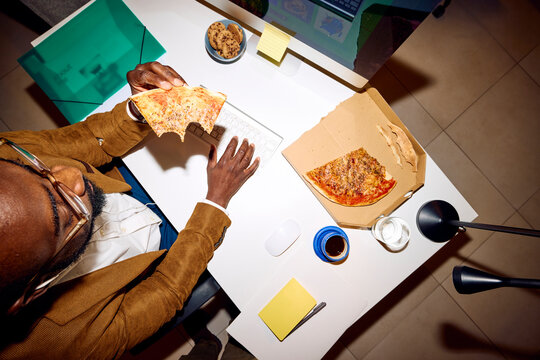 Man grabs a slice of pizza at work