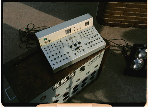 A vintage audio mixer set near terrace benches