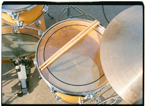 Drumsticks placed on a drum in a drum kit