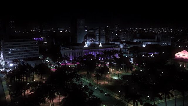 Night aerial view of Recife highlighting the Pal&aacute;cio do Campo das Princesas, city lights, historic architecture, and vibrant urban atmosphere.