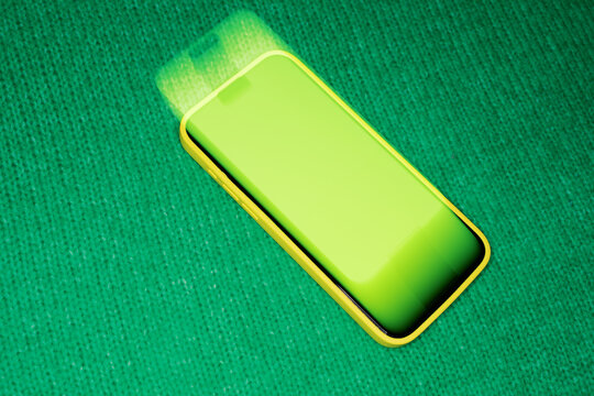 Bright Phone Placed on Green Surface With Light Reflection