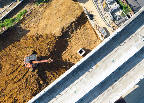 Elevated MRT Viaduct Construction with Excavator Earthwork Below