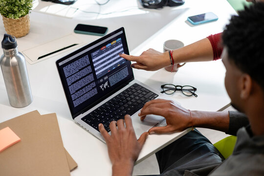 Colleagues collaborating on laptop analysing business data