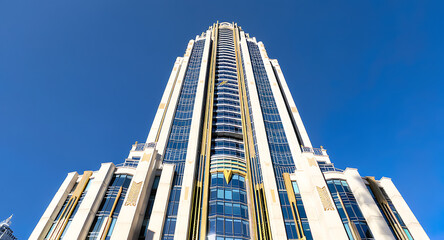 Naklejka premium Striking Art Deco Inspired Skyscraper Architecture Against Blue Sky.