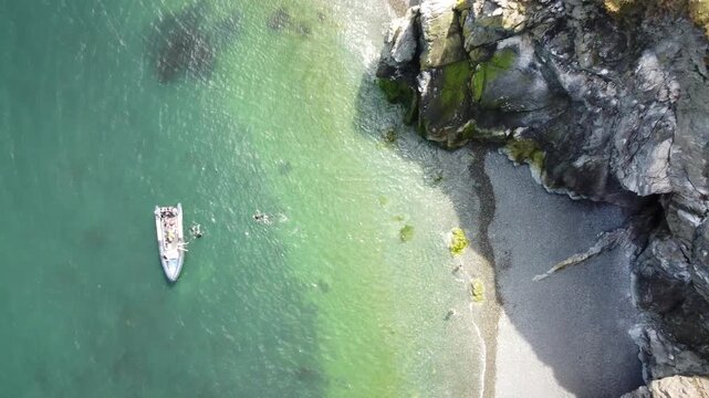 High angle aerial of a boat in clear turquoise water.
