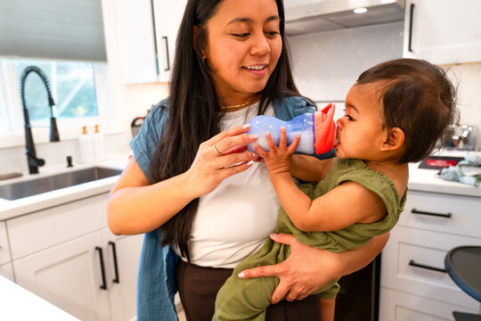 mom feeding toddler milk