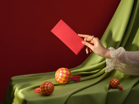 A delicate hand presents a red envelope, celebrates the new year