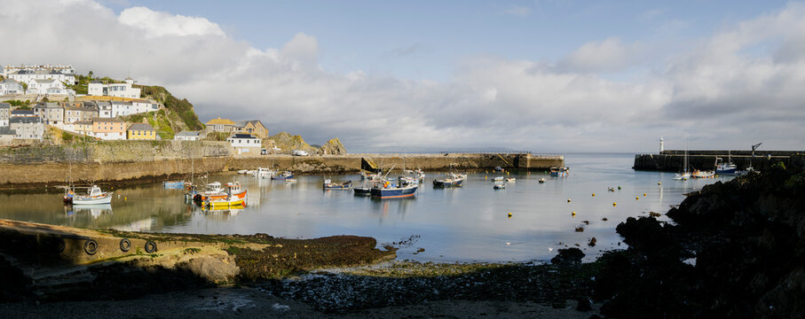 Mevagissey harbour village with boats in a calm coastal harbour