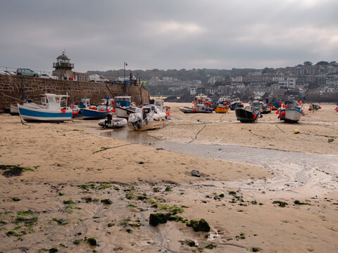 Boats anchored on a sandy harbour beach in St Ives