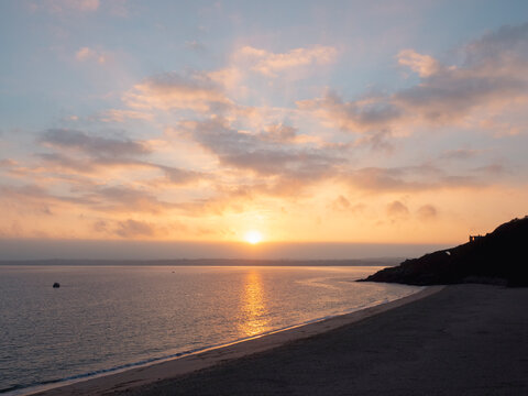 Sunrise over peaceful beach by calm sea tonight
