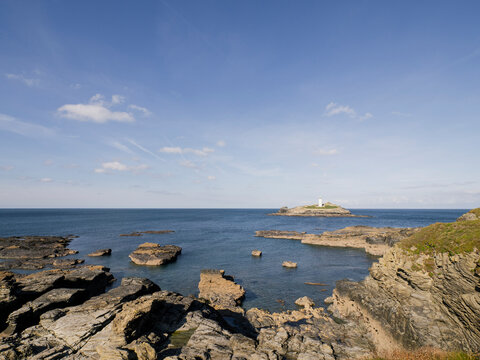 Lighthouse on a small island off rocky coast
