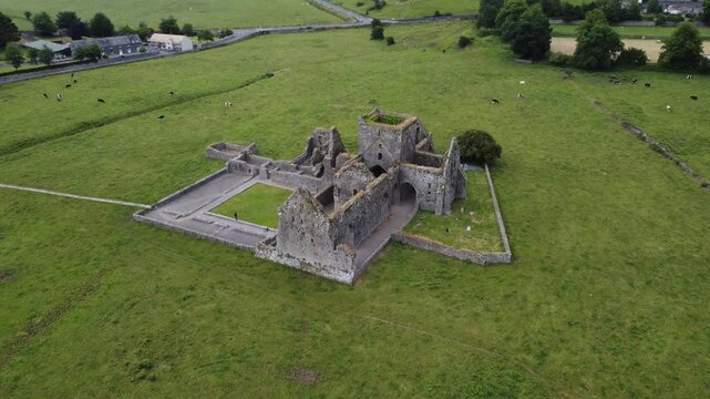 Side perspective of ancient monastery ruins in an open field.