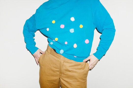 Person wearing shirt with colourful furry dots with direct flashlight