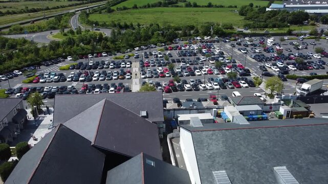 Aerial view of a large parking lot and modern buildings.