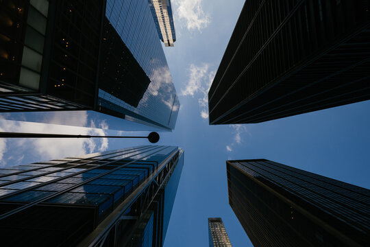 Glass skyscrapers viewed from below against blue sky