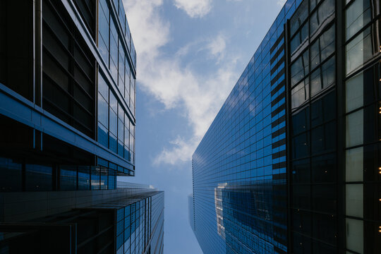 Blue glass skyscrapers under scattered clouds