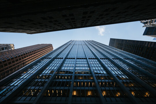 Tall glass skyscraper framed by surrounding buildings