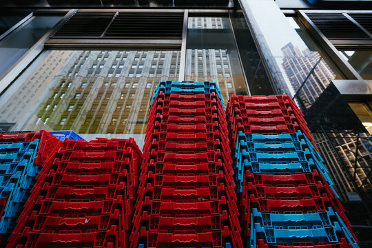 Stacked red and blue crates in urban reflection