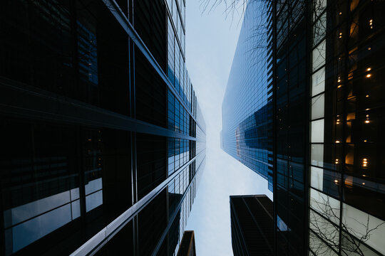 Narrow corridor view between glass skyscrapers