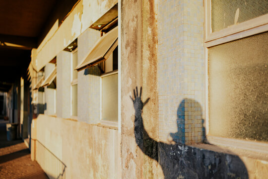 Shadow hand on sunlit wall of urban building