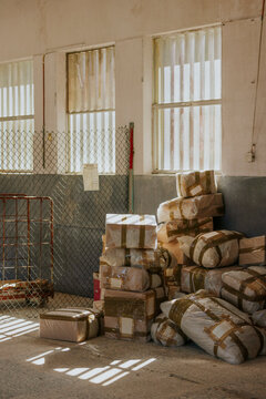 Packages stacked in warehouse corner with sunlight