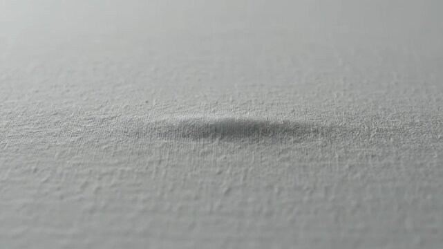 Close-up of white textured surface tearing and revealing a dark void