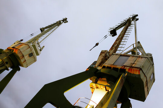 Industrial cranes under cloudy sky