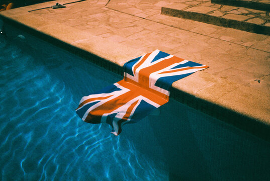a United Kingdom flag towel slipping into a swimming pool, 35mm film