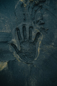 Handprint in Dark Volcanic Sand