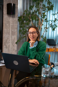 Confident businesswoman working on a laptop in a modern office
