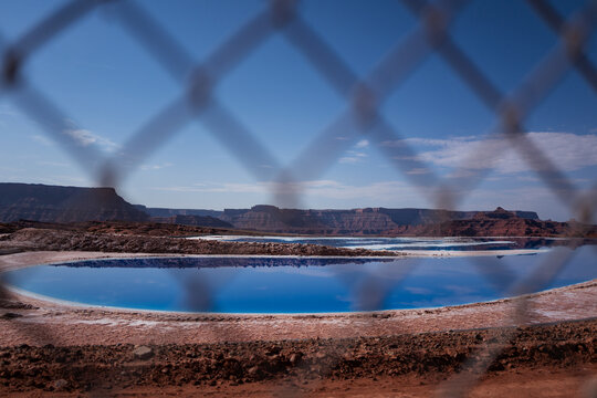 Through a wire fence to the blue potash evaporation ponds near Moab
