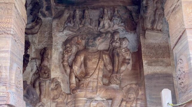 Varaha avatar of Lord Vishnu rescuing Bhudevi, gently carrying her on a lotus as she places her hand on his face in faith. Sheshnaag carved below. 1300-year-old Badami Caves, Karnataka.