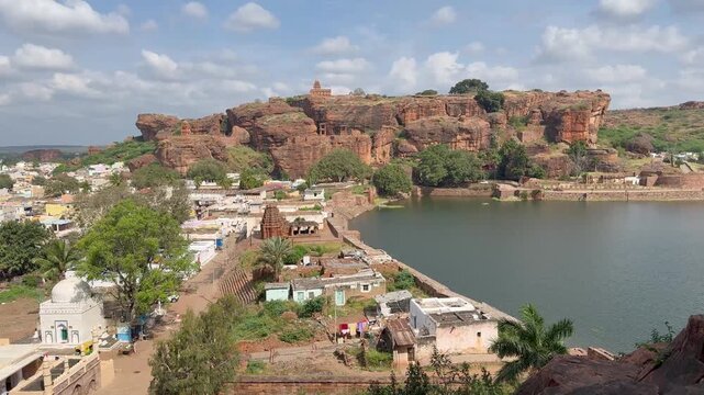 Aerial view of Agastya Lake and its temples, seen from the Badami caves, framed by the majestic red sandstone hills