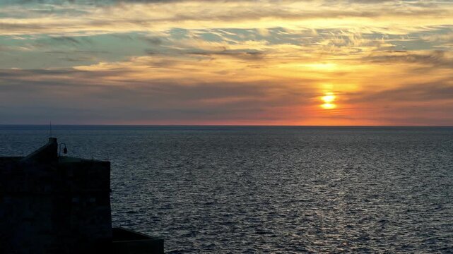 Golden hour at Citadella in Victoria Gozo Malta with Mediterranean sea view under orange sunset sky and dramatic clouds during autumn evening with wide angle perspective and warm coastal light