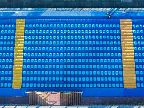 Top-Down View of Blue Stadium Seats with Yellow Borders

