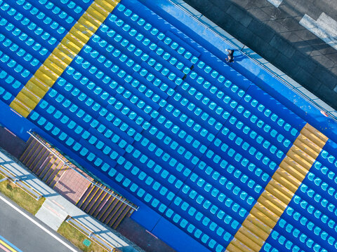 Top-Down View of Blue Stadium Seats with Yellow Borders

