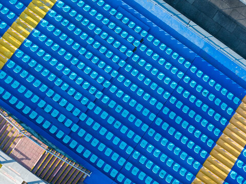 Top-Down View of Blue Stadium Seats with Yellow Borders

