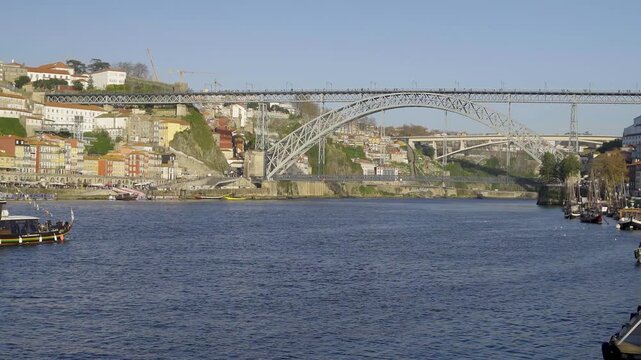 Closer daytime view of the metallic bridge structure and river landscape.