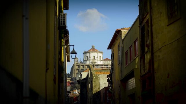 Low angle view through a Porto urban alley towards the landmark.