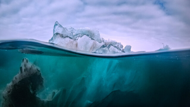 Translucent iceberg melting under water - climate change