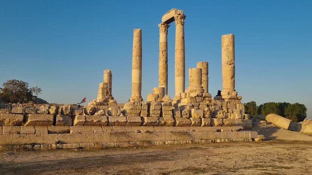 Warm sunset light bathes the ancient ruins of the Temple of Hercules on Amman Citadel Hill, Jordan, revealing weathered stone architecture and creating a calm, timeless golden-hour mood