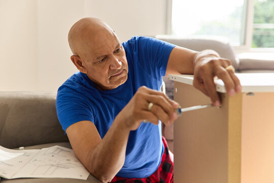 Man Assembles Furniture in Living Room During Afternoon Hours