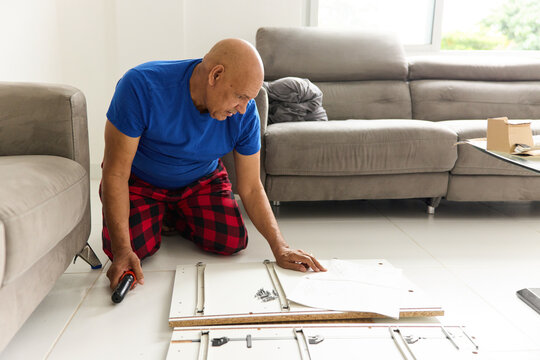 Man Assembling Furniture in a Living Room During Daytime