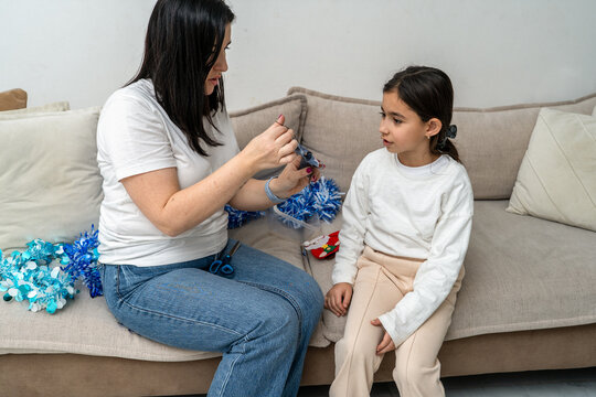 Mother And Daughter Making Christmas Decorations At Home
