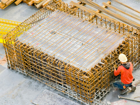 Worker Fixing Rebar Cage and Structural Detail at Construction Site