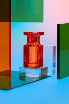 Elegant orange perfume bottle displayed on acrylic stands