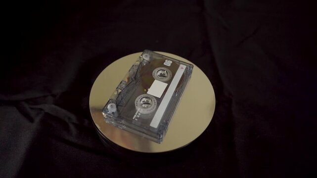 Wide shot of a classic 90s audio cassette on a dark surface.