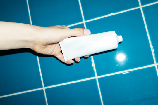 Hand holding mock up lotion tube with space for text or design 