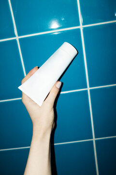 Hand holding mock up lotion tube with space for text or design 